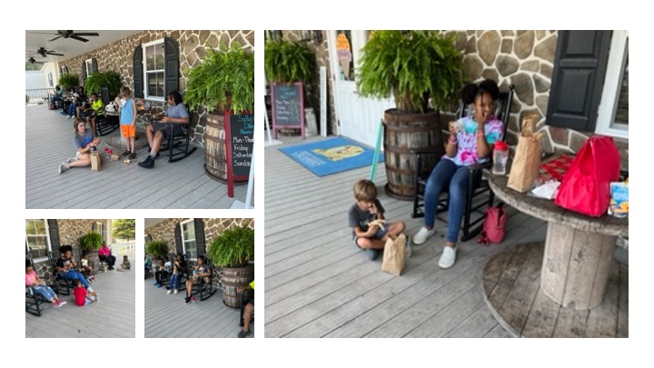 Campers relax and eat lunch on a porch