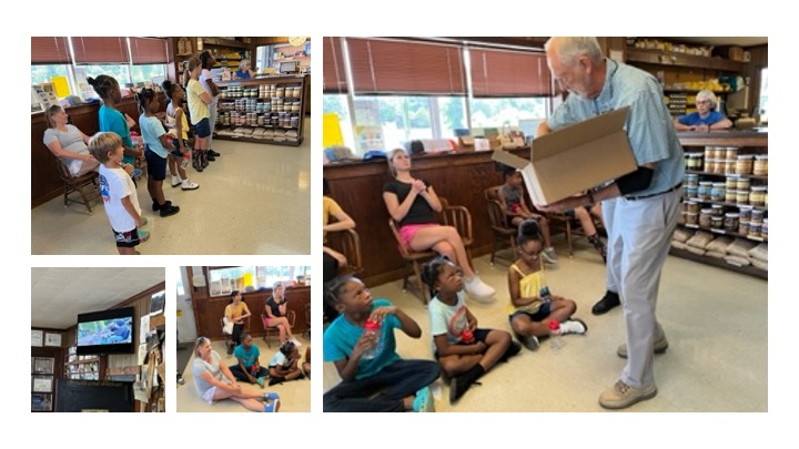 A man gives a presentation to campers in a store.