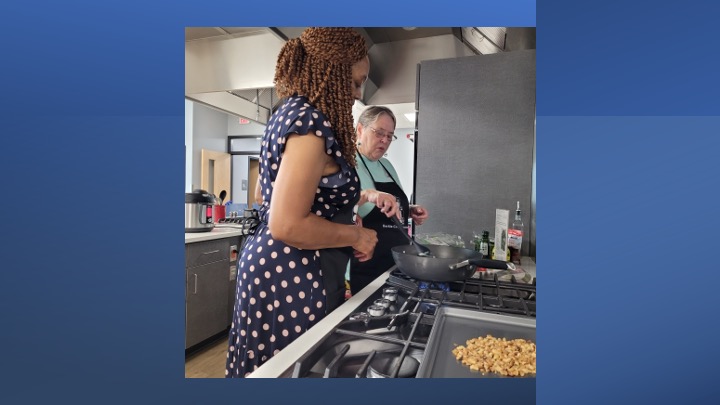 Two women cook a meal.