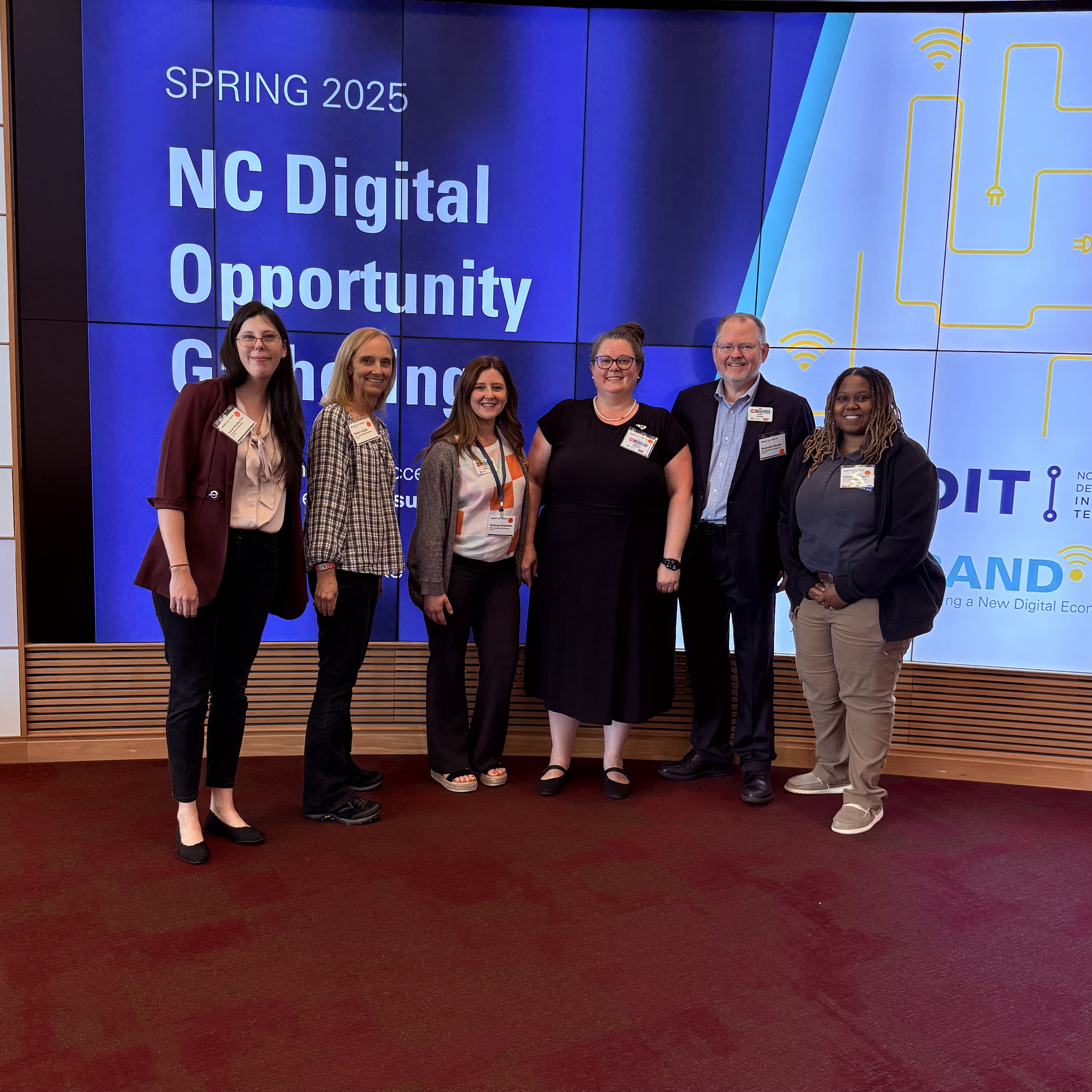 Six members of N.C. Cooperative Extension’s Digital Futures team standing together and smiling at the NC Digital Opportunity Gathering in April 2025.