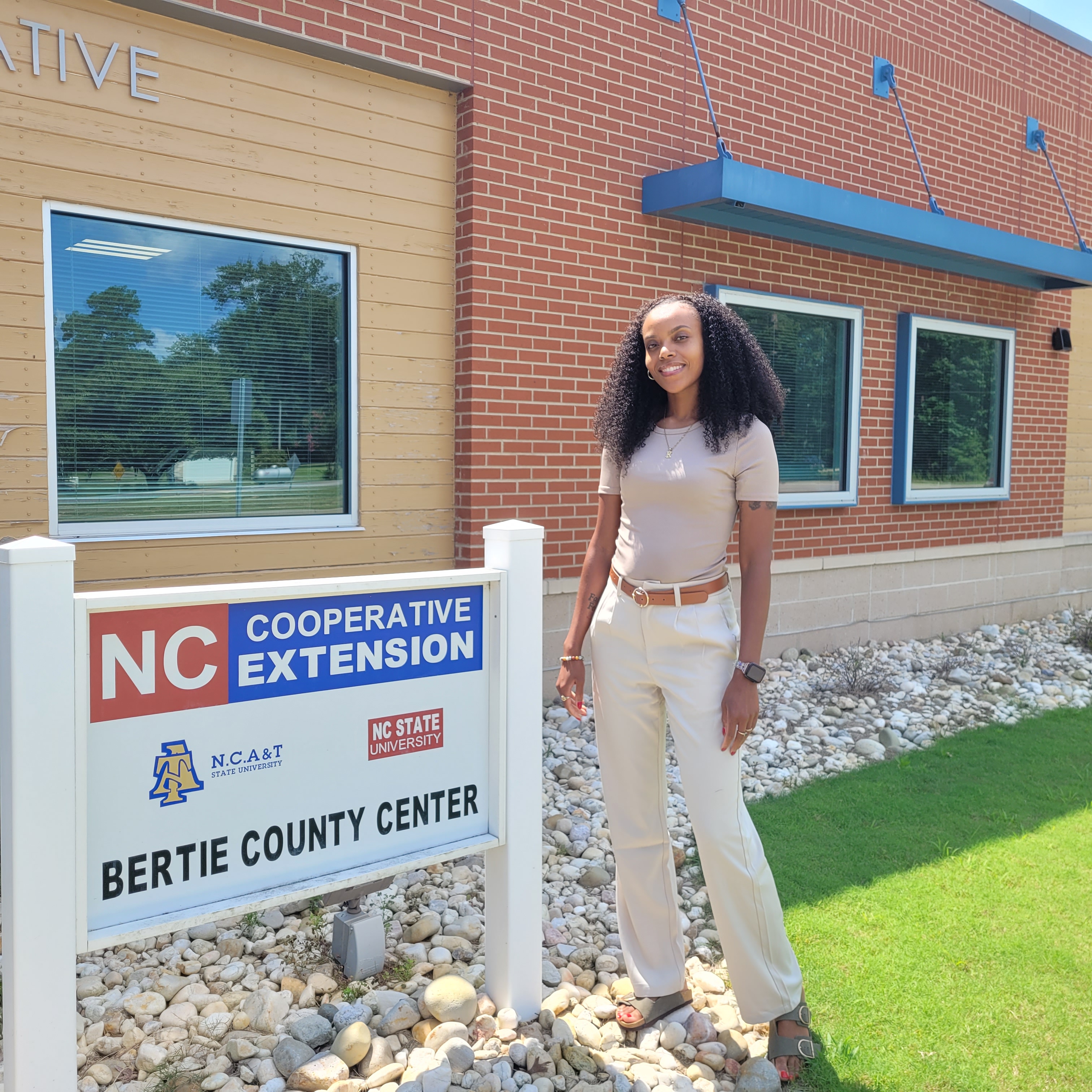 A woman standing by a sign that reads N.C. Cooperative Extension, Bertie County Center